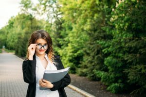 Starting a Business, startup, Outdoor Portrait of young business woman in glasses and with documents